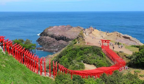The Exquisite Vermillion Torii Gate Of The Motonosumi Shrine, Set Against The Backdrop Of The Japan Sea!